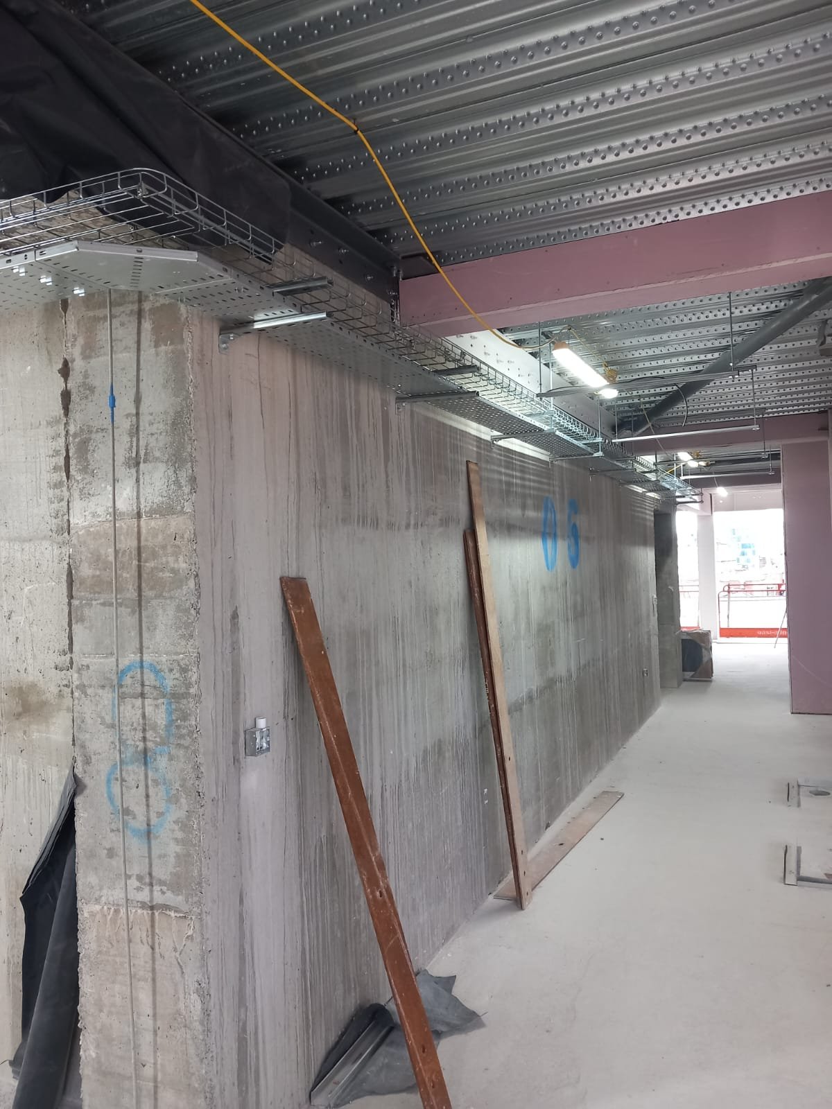 Industrial electrical installation with cable trays, conduit, and suspended lighting at commercial site by U & O Electrical Manchester